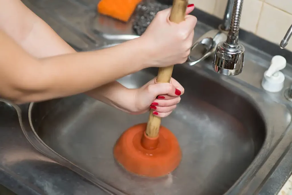 toilet plunger being used to unclog sink