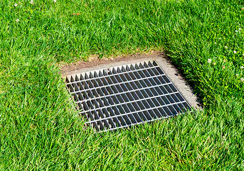 Dig gravel beneath grass to access basin clog