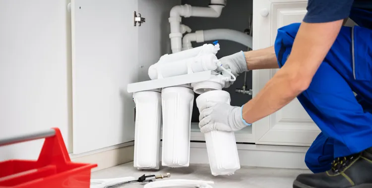 Expert plumber installs a RO system under a kitchen sink