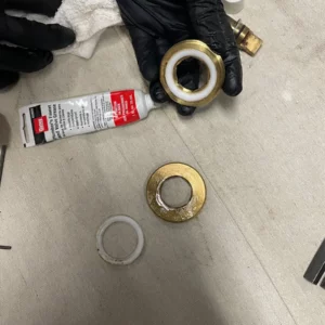 Repair kit tools showing old and new gaskets and washers before plumber company installs in kitchen sink