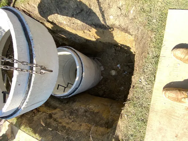 crane placing piece in manhole for flood control system