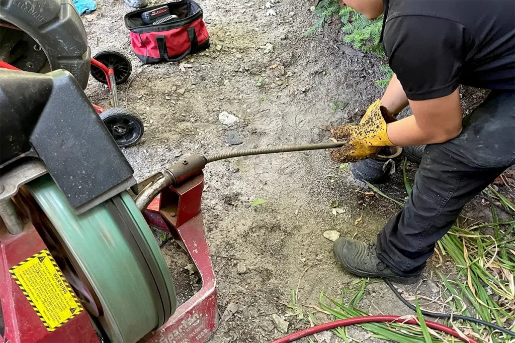 Plumbing system conducting drain cleaning on sewer line
