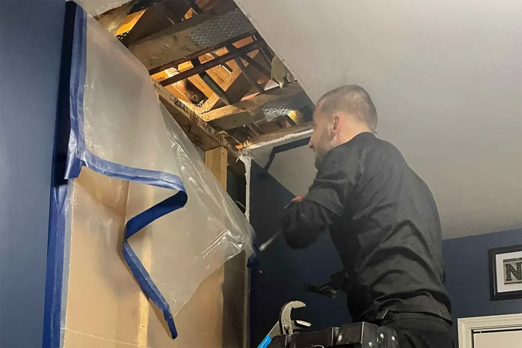 licensed plumber removing drywall to locate water leak