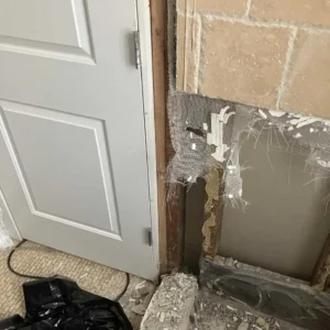 Shower wall tiles removed for water damage restoration