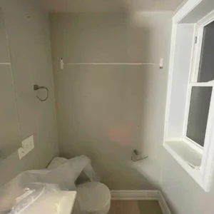 Restored bathroom with clean, repaired interior walls, isolation used to protect building materials.