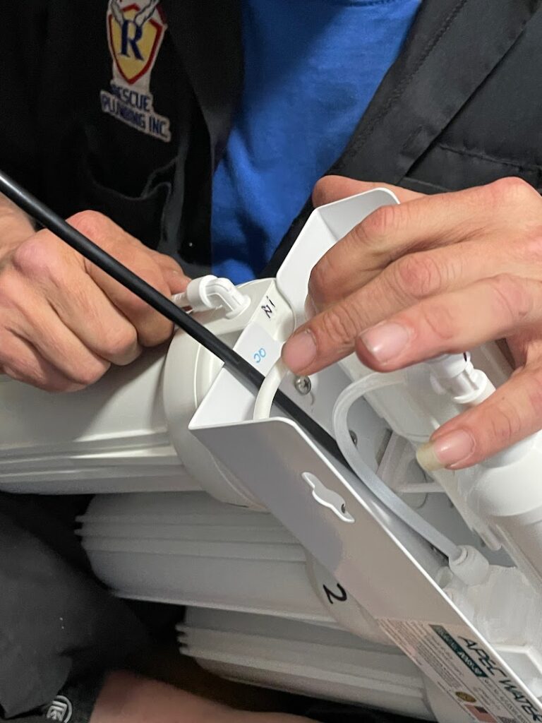 Expert plumber installing a purification swater system