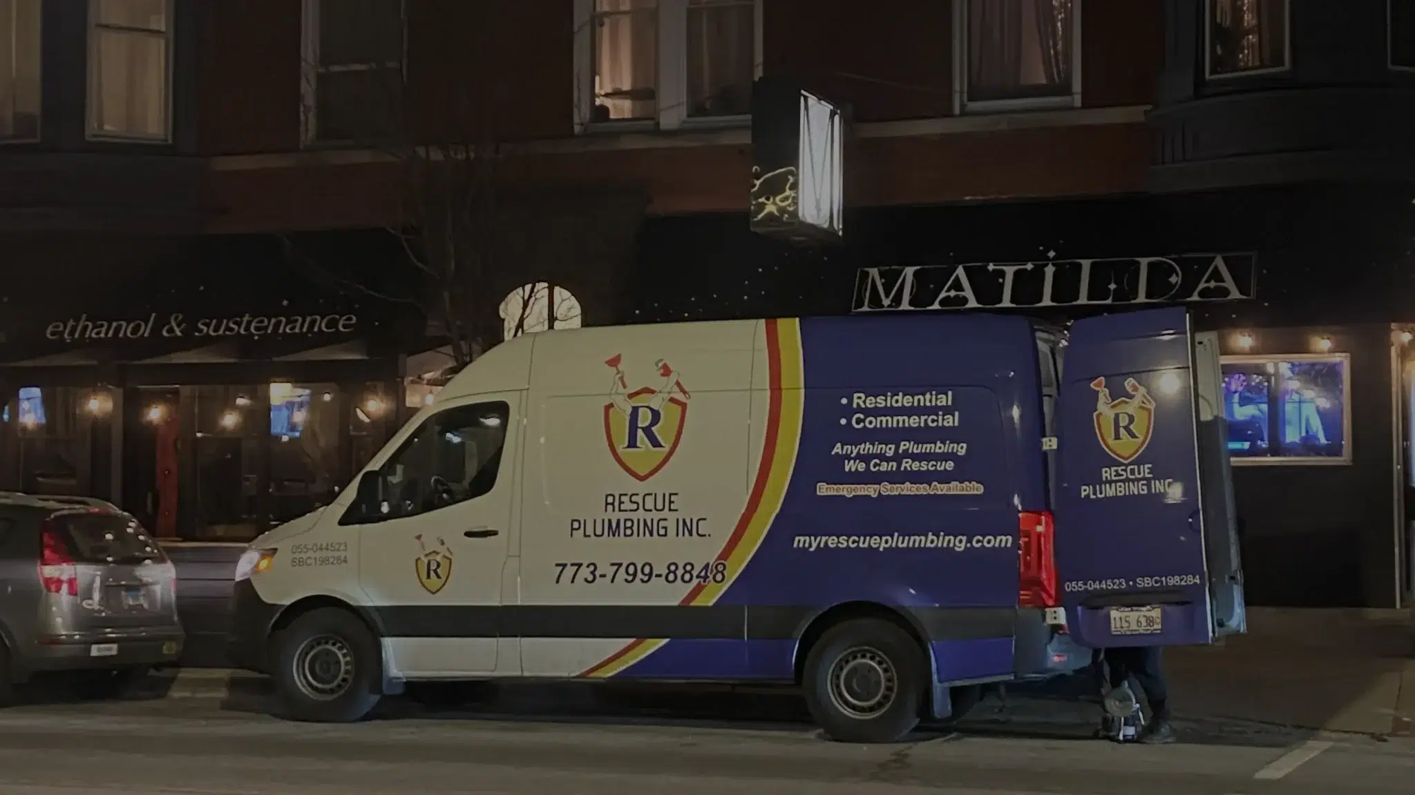 Rescue Plumbing van with Chicago Wrap vehicle wrap driving through a Chicago neighborhood